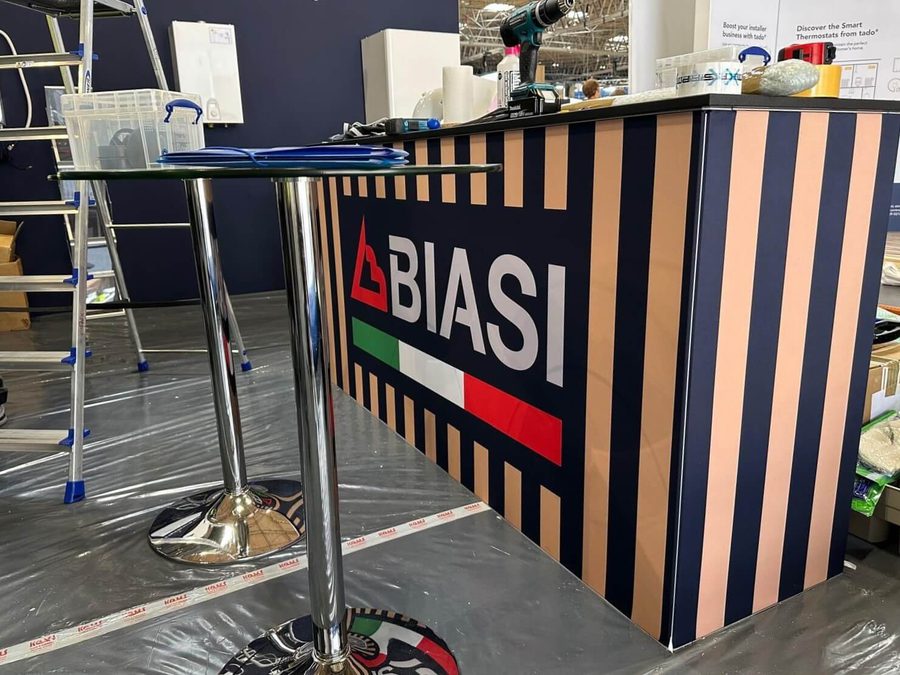 Close up of the construction of the front desk at the Biasi Installer Show stand, with two tall tables just in front.