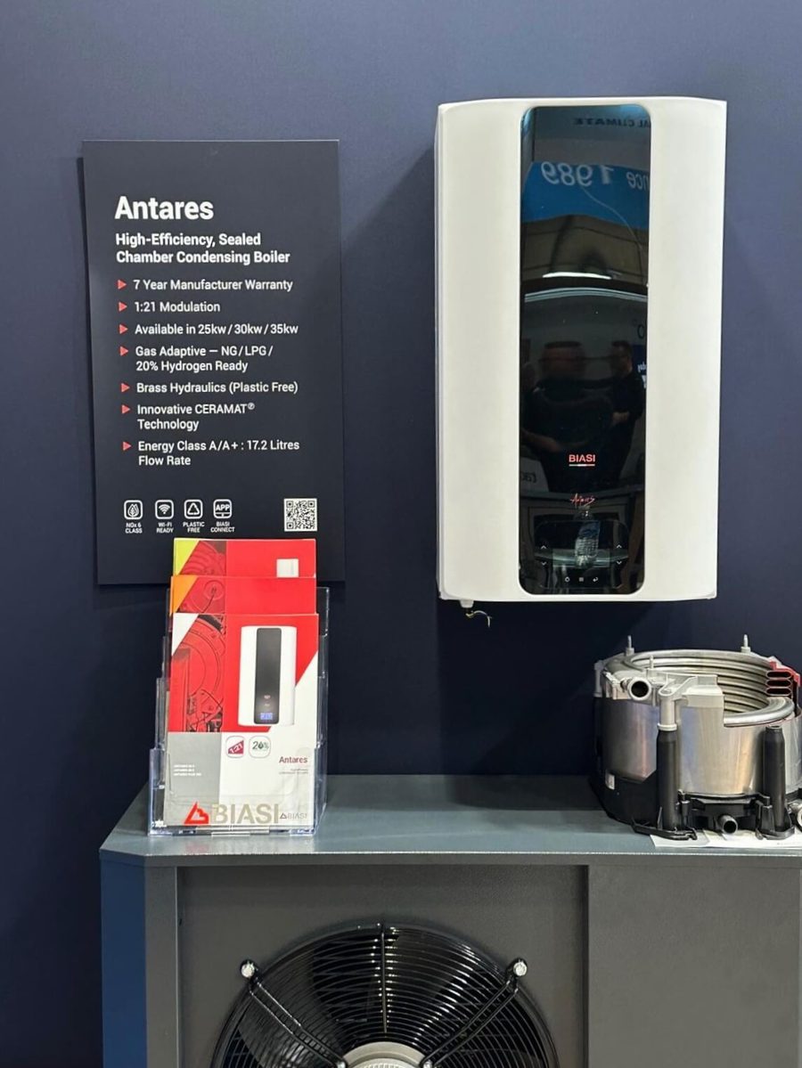 close up of a biasi boiler mounted to the installer show wall along with a foam board with text on it regarding the antares boiler. Leaflets are in a stand underneath it on top of a plinth,