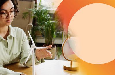 A woman spinning a model wind turbine with her finger