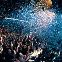 Crowd of people being showered with confetti.