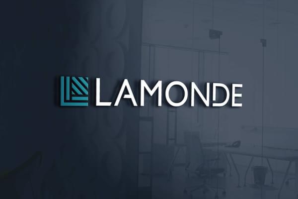 The Lamonde logo artistically rendered at a slight angle. The glassy blue background shows a subtle reflection of an office interior.