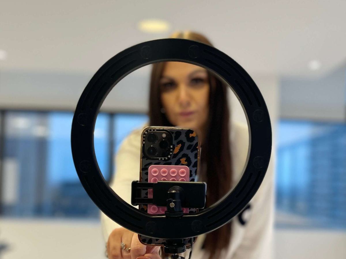 Image of ring light stand containing a phone from the view of somebody who is being recorded
