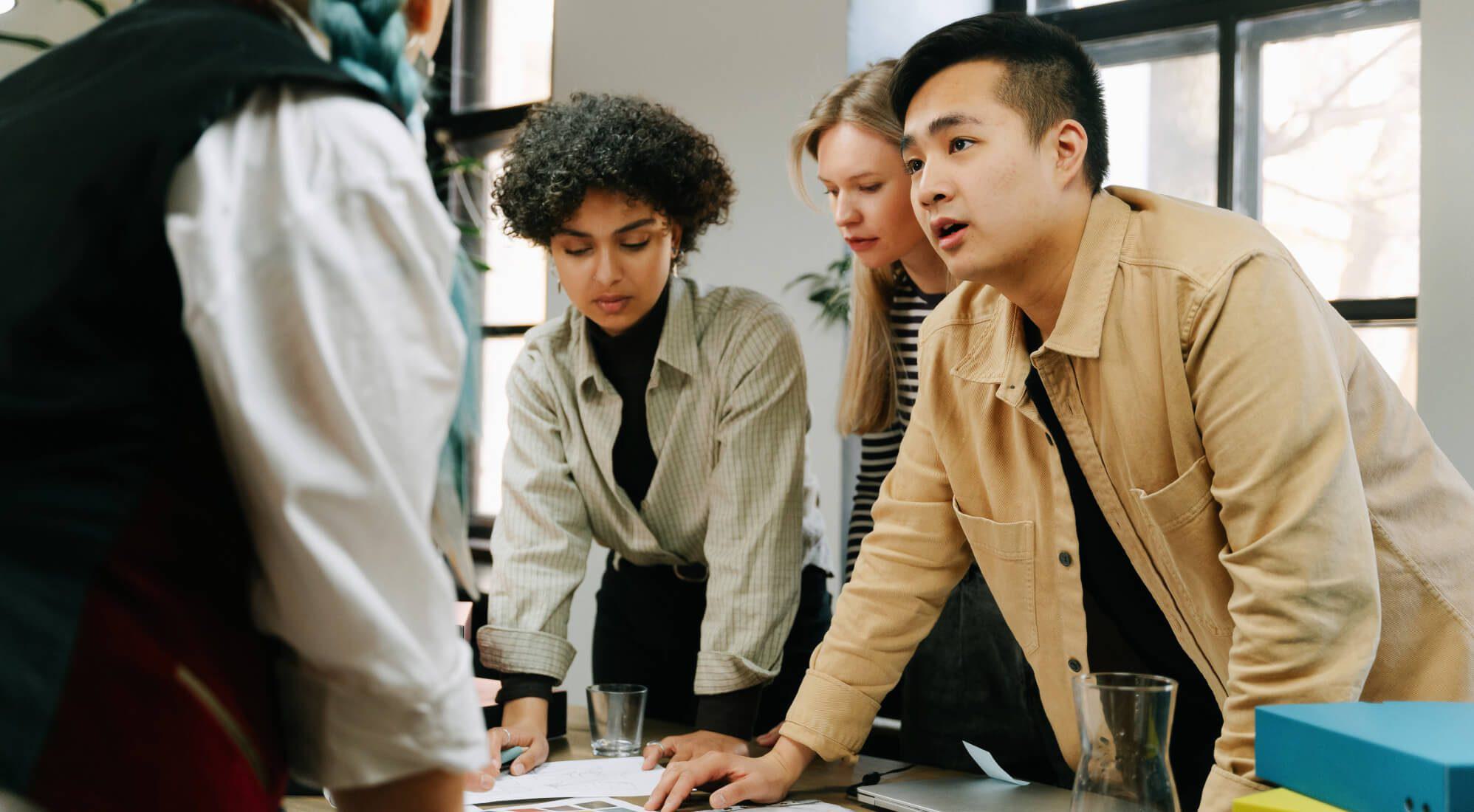 Team gathered around a desk, having a discussion