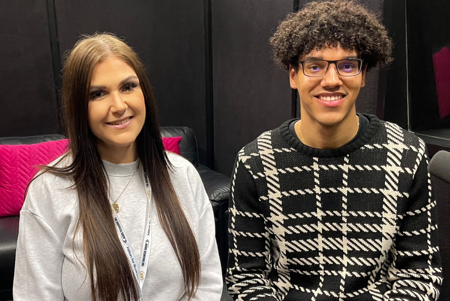 Emma and Jamie sat in the podcast studio smiling towards the camera